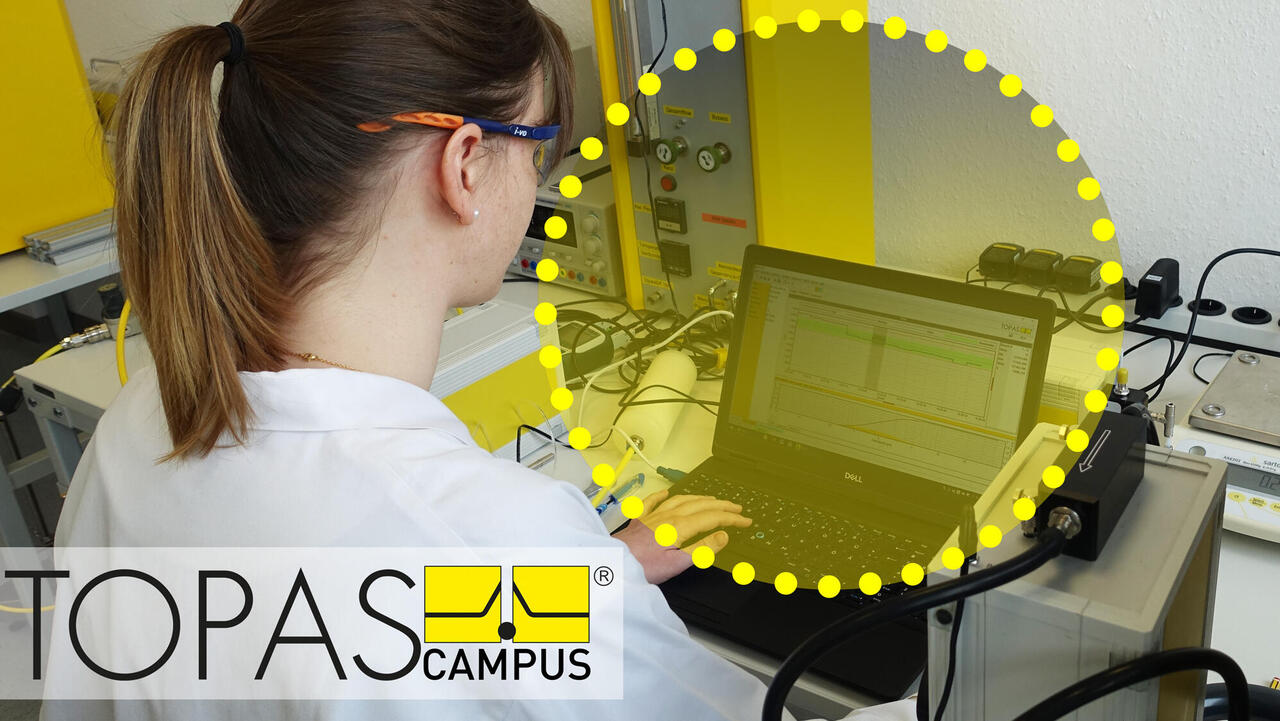 Wissenschaftlerin bei Auswertung von Daten am PC, Topas-Campus-Logo im Vordergrund