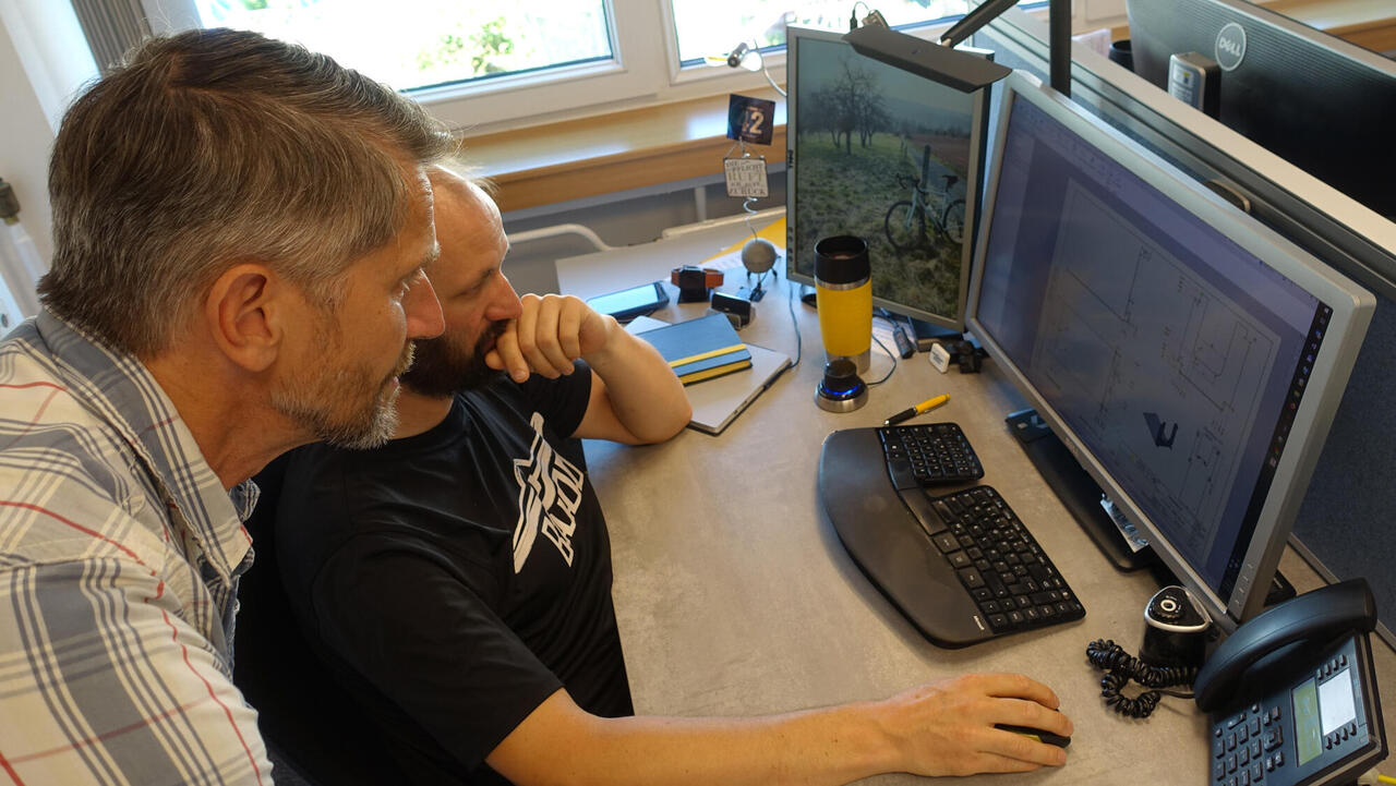 Engineers in discussion in front of a screen