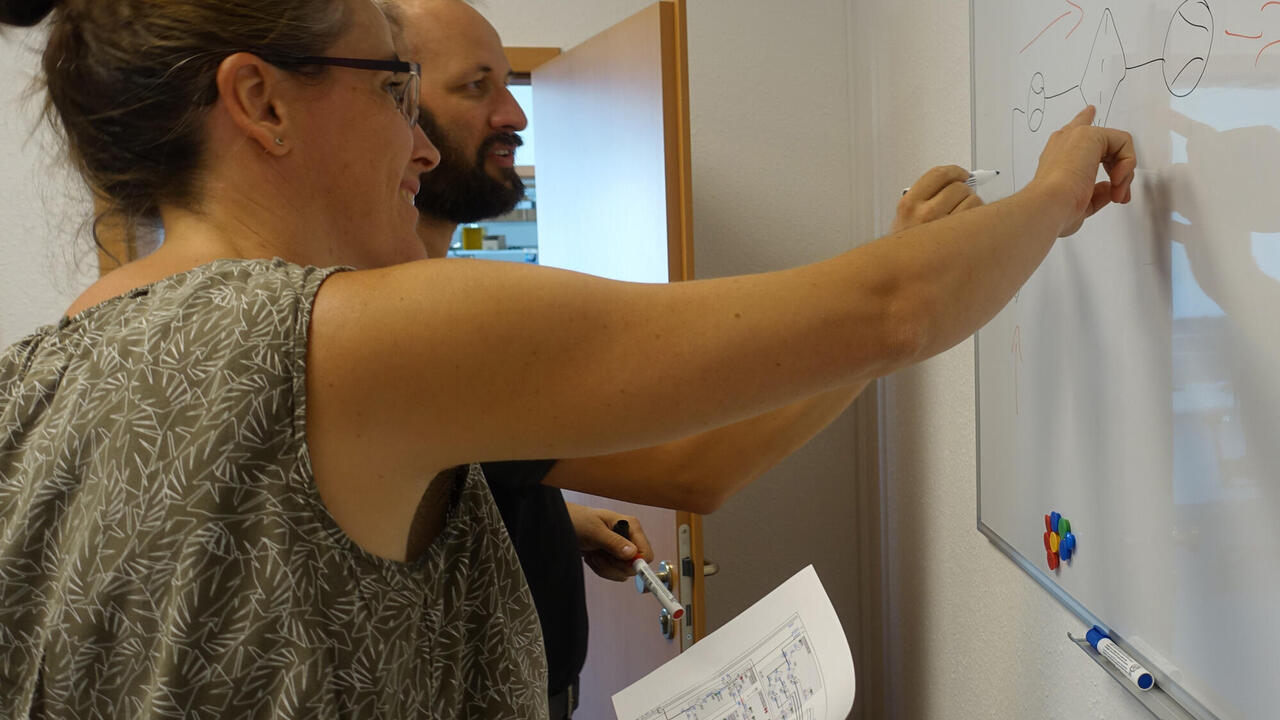 Engineers talk about a technology problem using a whiteboard