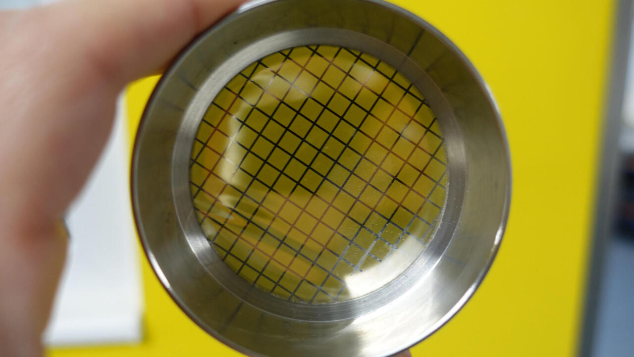 Hand with fine sieve against a yellow background