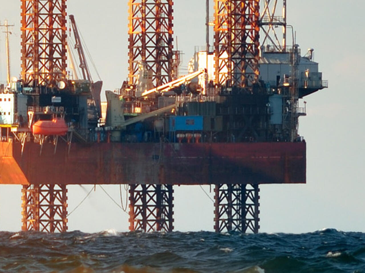 Bohrinseln im Meer mit schäumender Gischt im Vordergrund