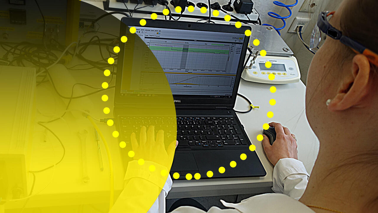 Forschungslabor, Mensch am Rechner über die Schulter geschaut mit gelben Kreisen im Vordergrund