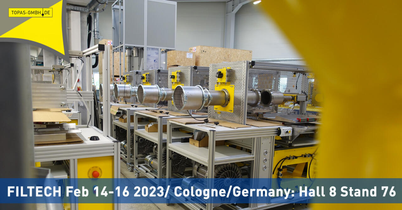 Produktionshalle Topas GmbH mit Prüfständen im Hintergrund, vorn Information zur FILTECH 2023